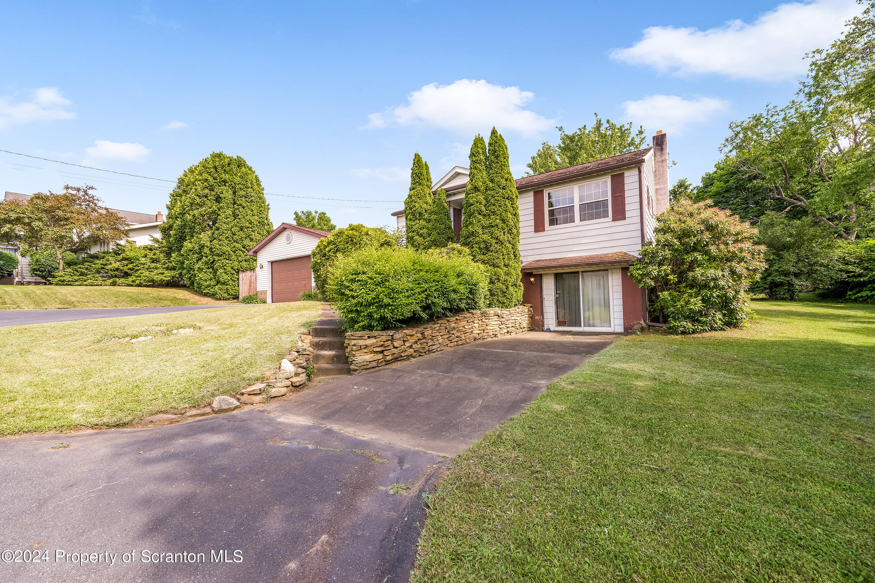 254 Hoover Street Old Forge, PA 18518 - Photo 3 of 27 a front view of a house with garden and trees