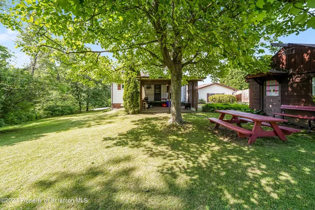 a view of a house with backyard and sitting area