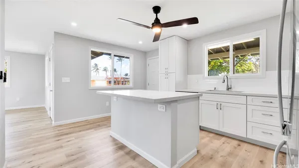 a kitchen with white cabinets and window