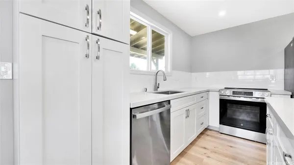 a kitchen with stainless steel appliances granite countertop a sink and a stove