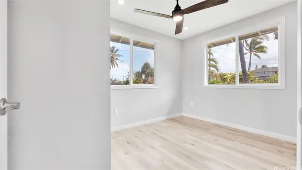an empty room with windows and a ceiling fan