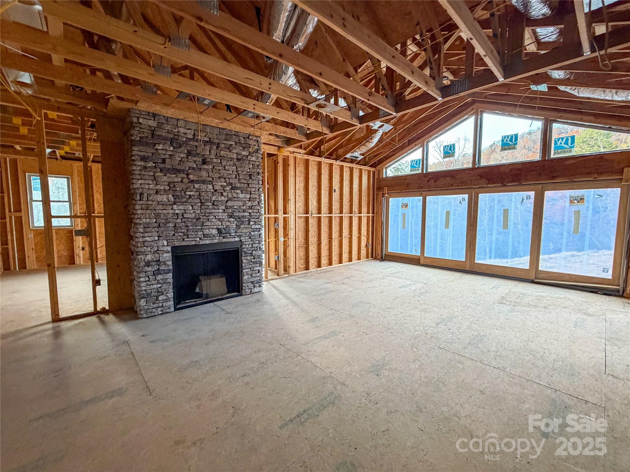 864 Matho Trace Lake Lure, NC 28746 - Photo 6 of 47 a view of an empty room with a fireplace and a window