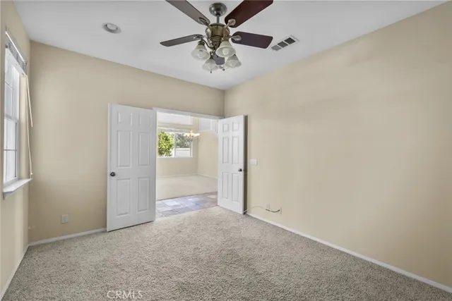 an empty room with closet and fan