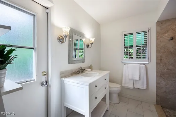 a bathroom with a sink toilet and window