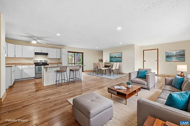 a kitchen with granite countertop a refrigerator a stove a sink and white cabinets