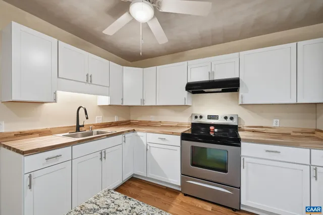 a kitchen with granite countertop a sink and a stove