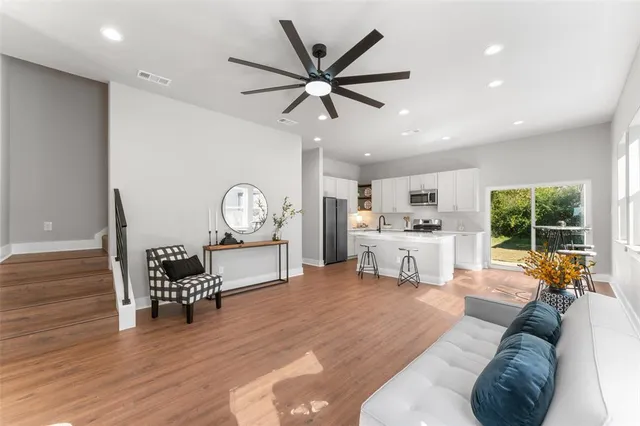 a living room with furniture and a large window with wooden floor