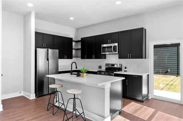 a kitchen with stainless steel appliances a microwave sink refrigerator and cabinets