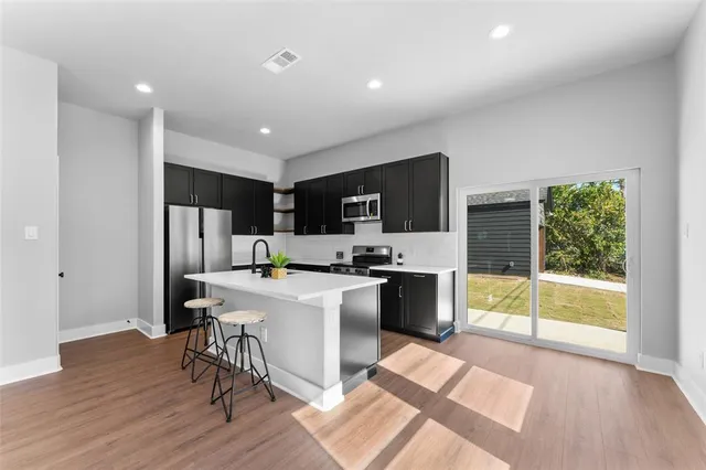 a kitchen with a sink a counter top space stainless steel appliances and cabinets