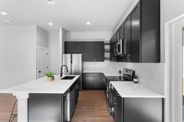 a kitchen with stainless steel appliances a sink a stove and a refrigerator