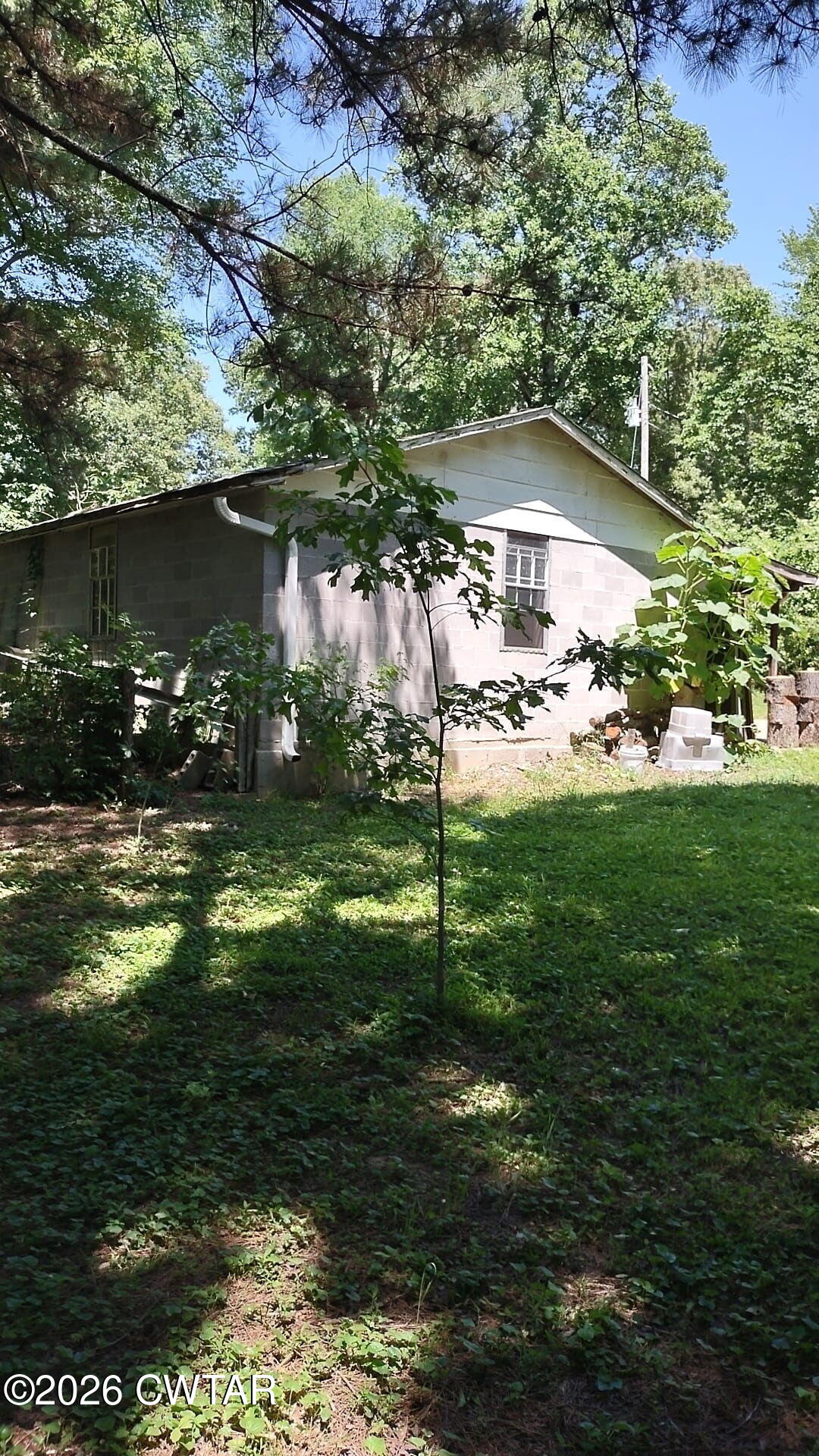 195 Ridge Road Medina, TN 38355 - Photo 7 of 14 a backyard of a house with table and chairs under an umbrella