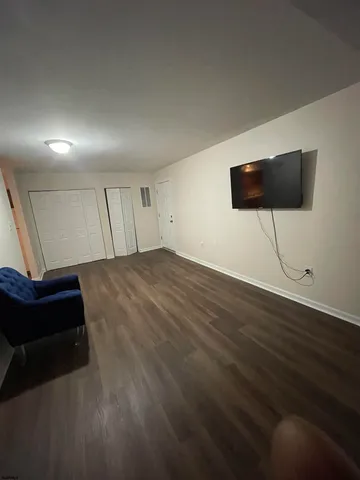 a view of a room with wooden floor and lounge chair