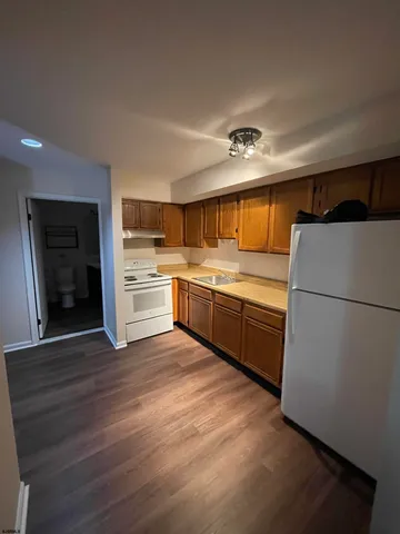 a kitchen with stainless steel appliances a sink and wooden floor