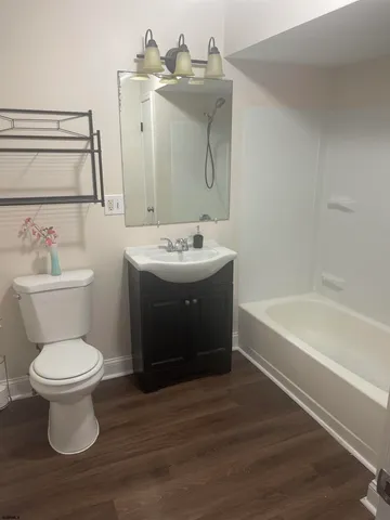 a view of a livingroom with wooden floor and a flat screen tv