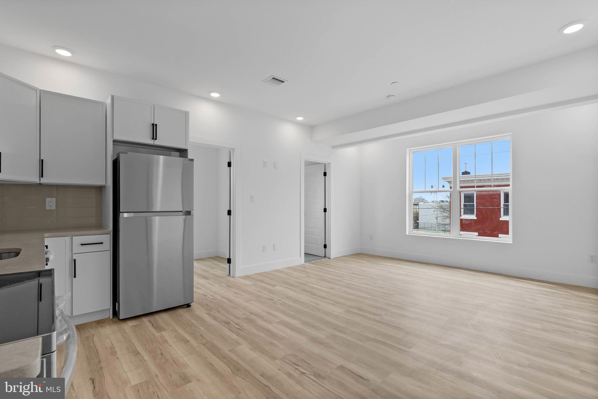 809 Diamond Street, Unit 401 Philadelphia, PA 19122 - Photo 3 of 15 a view of a kitchen with a refrigerator a microwave and a sink