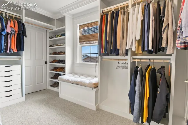 a view of walk in closet with clothes and shoes