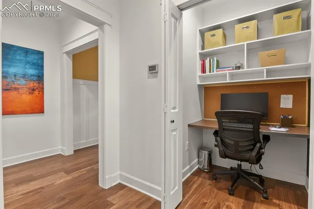 a view of a workspace with furniture and wooden floor