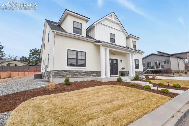 a view of a white house with swimming pool next to a yard