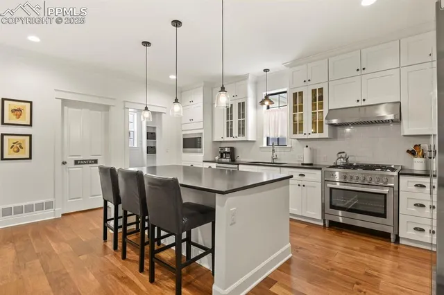 a kitchen with stainless steel appliances granite countertop a stove a sink island and a refrigerator