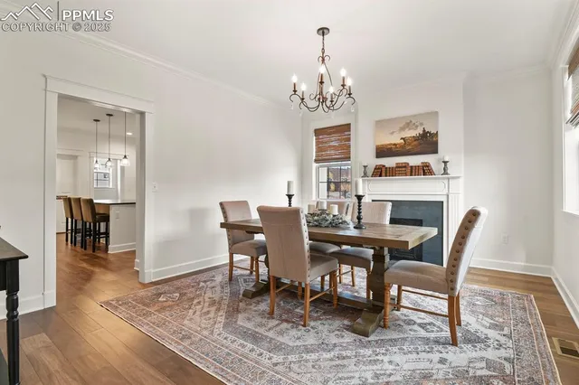 a view of a dining room with furniture a chandelier and wooden floor