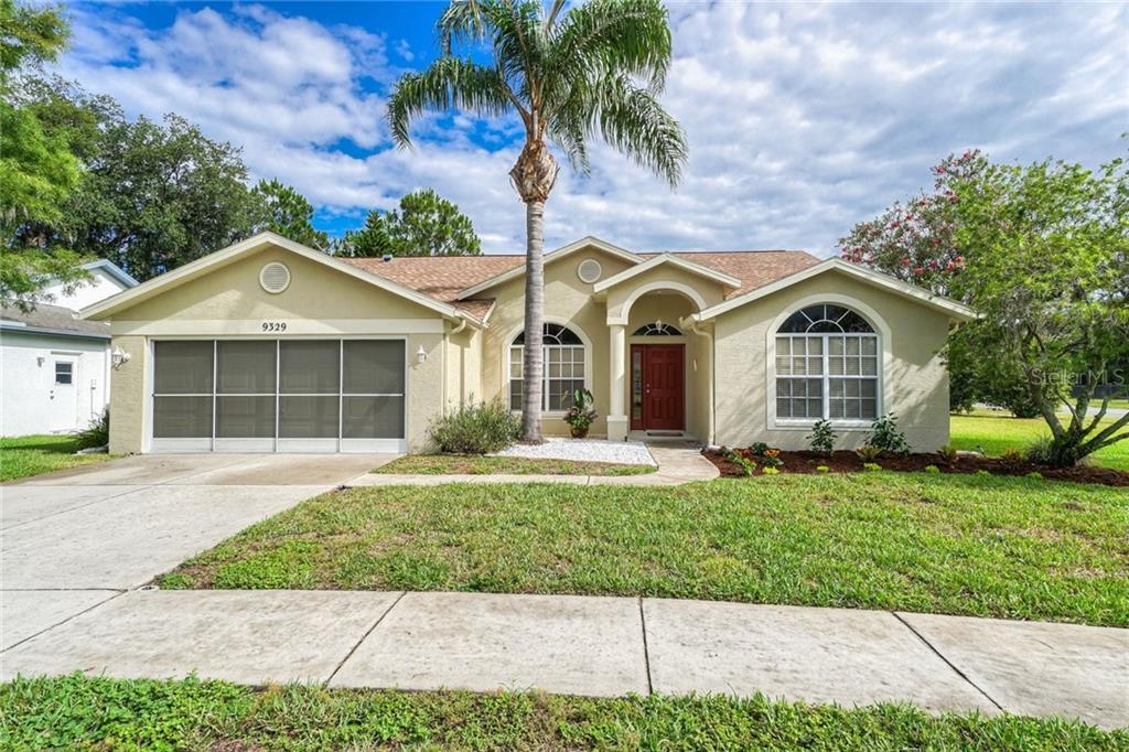 9329 Bearcat Road New Port Richey, FL 34655 - Photo 1 of 1 a front view of a house with a garden