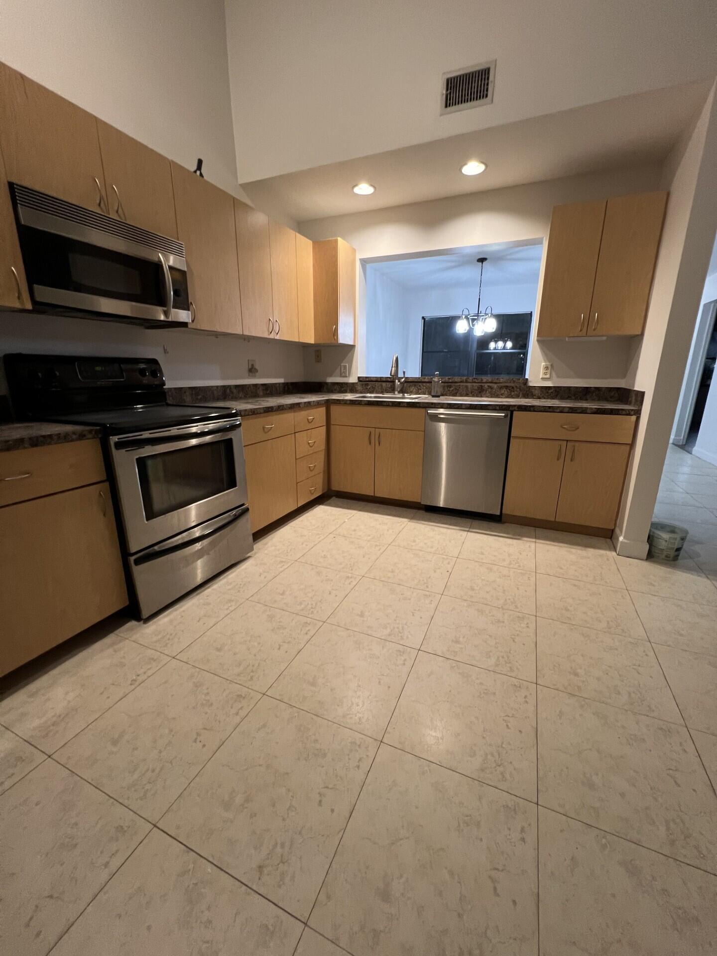 a kitchen with stainless steel appliances and a counter top space