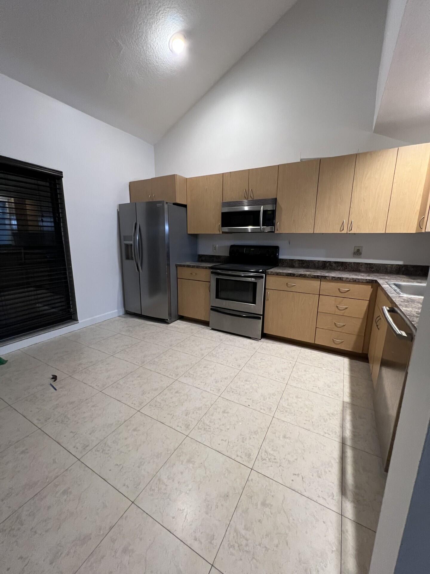9314 Ketay Circle Boca Raton, FL 33428 - Photo 6 of 22 a kitchen with stainless steel appliances a refrigerator and a stove top oven