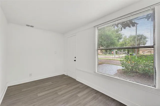 a view of a room with wooden floor and a window