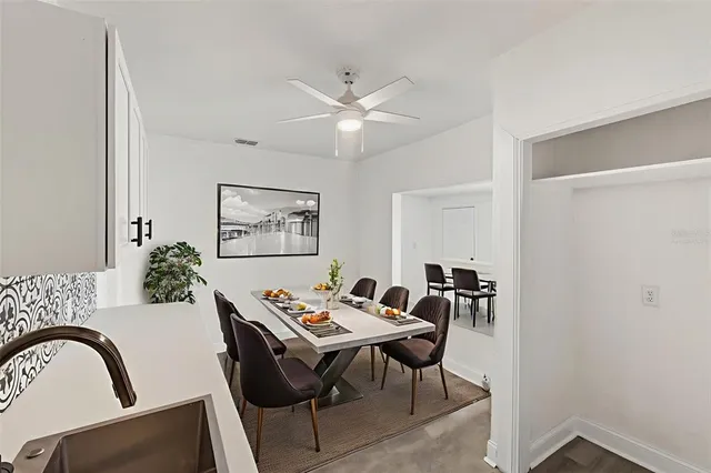 an empty room with wooden floor cabinet and windows