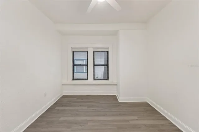 a view of an empty room with wooden floor