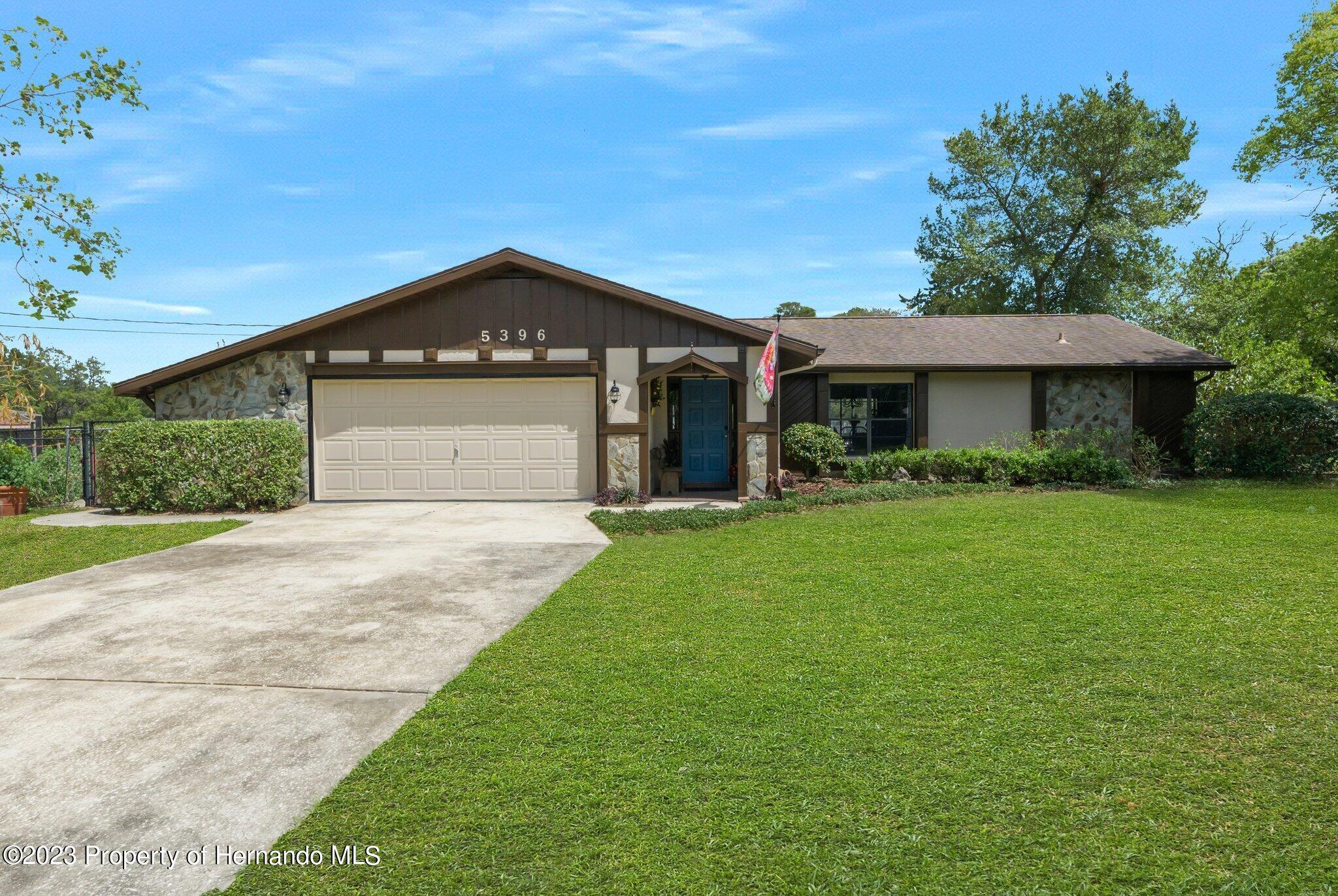 5396 Fern Weeki Wachee, FL 34607 - Photo 1 of 43 a front view of a house with a yard and garage