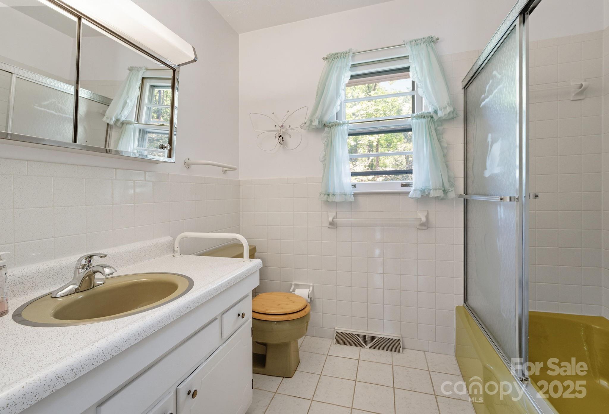 109 Rusty Lane Hendersonville, NC 28791 - Photo 19 of 34 a bathroom with a sink toilet and window