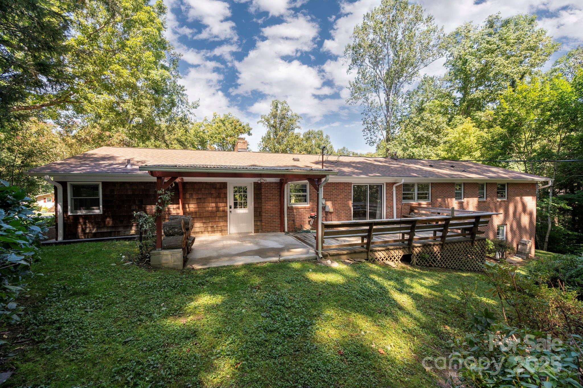 109 Rusty Lane Hendersonville, NC 28791 - Photo 3 of 34 a front view of a house with a garden and porch