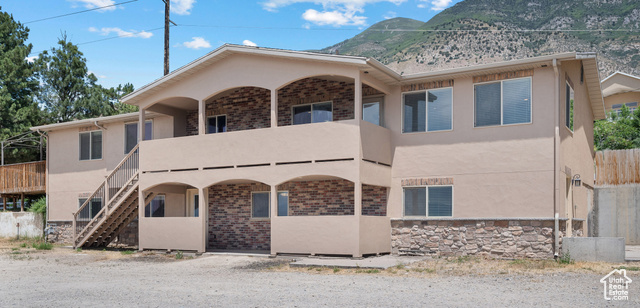 9096 Canyon Road Cedar Hills, UT 84062 - Photo 1 of 1 View of front facade featuring a balcony, stucco siding, a mountain view, and stairway