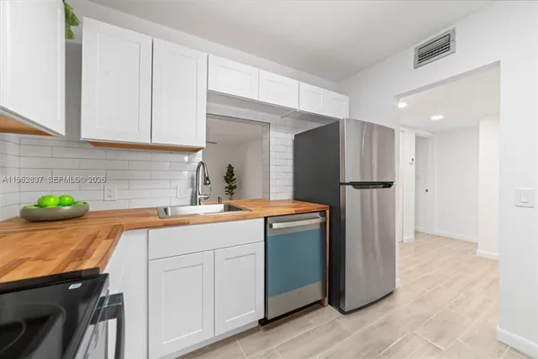 a kitchen with kitchen island a sink appliances and cabinets