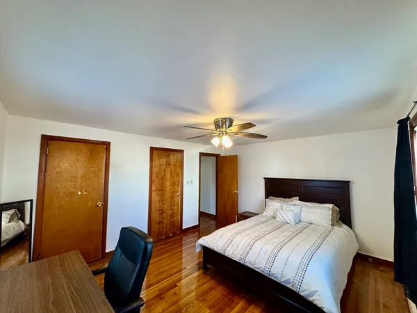 a bedroom with a bed and wooden floor