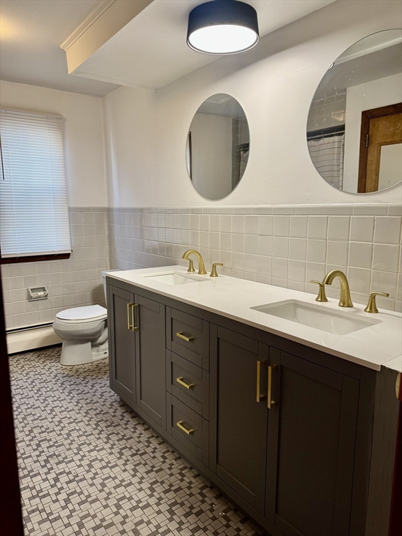 156 Nichols Avenue, Unit 1 Watertown, MA 02472 - Photo 16 of 26 a bathroom with a double vanity sink and a mirror