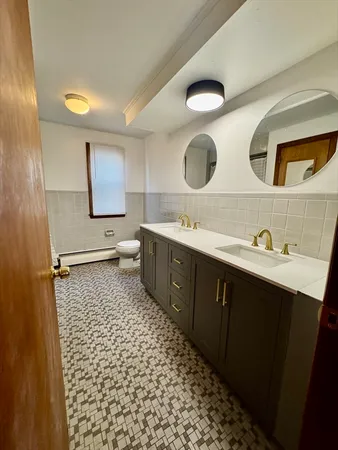 a bathroom with a sink a toilet and mirror
