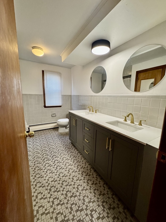 156 Nichols Avenue, Unit 1 Watertown, MA 02472 - Photo 17 of 26 a bathroom with a sink a toilet and mirror