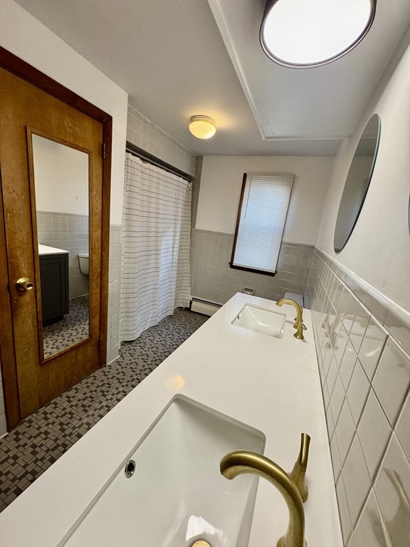 156 Nichols Avenue, Unit 1 Watertown, MA 02472 - Photo 18 of 26 a bedroom with a bed and a mirror