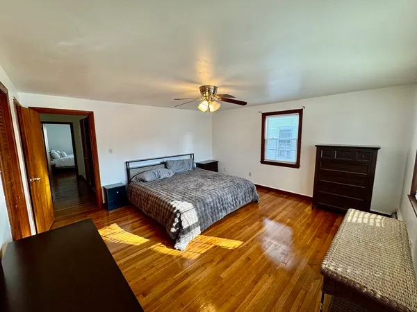 a bedroom with a bed and a dresser with rug