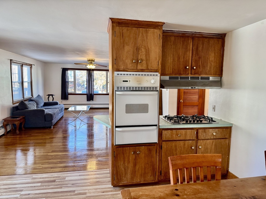 156 Nichols Avenue, Unit 1 Watertown, MA 02472 - Photo 7 of 26 a living room with stainless steel appliances granite countertop wooden floors a stove and a window