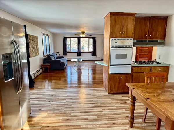 a kitchen view with wooden floor and furniture