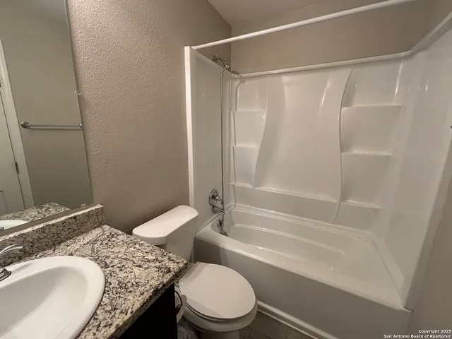 a bathroom with a granite countertop toilet sink and shower