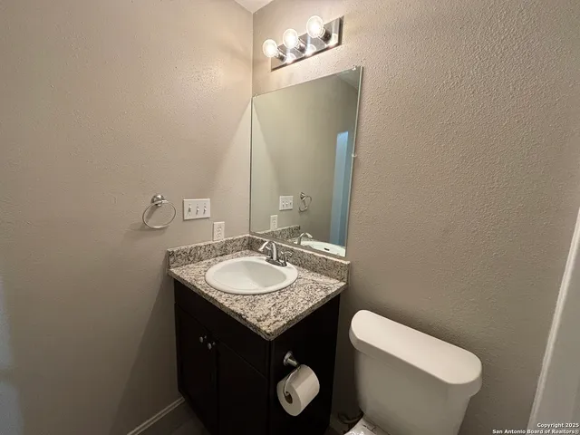 a bathroom with a toilet sink and mirror