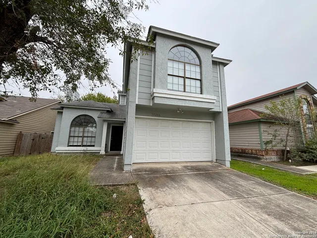 a front view of a house with a garden and garage