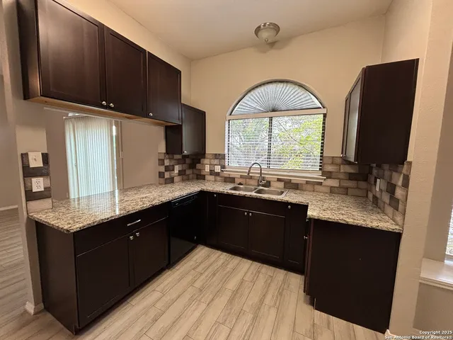 a kitchen with a sink a window and appliances
