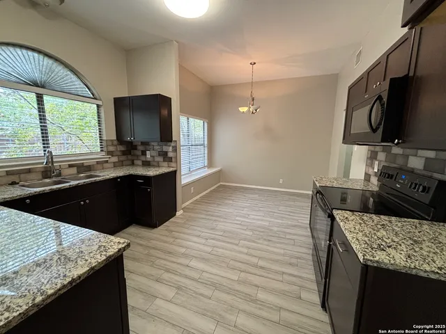 a kitchen with granite countertop counter top space a sink and a stove