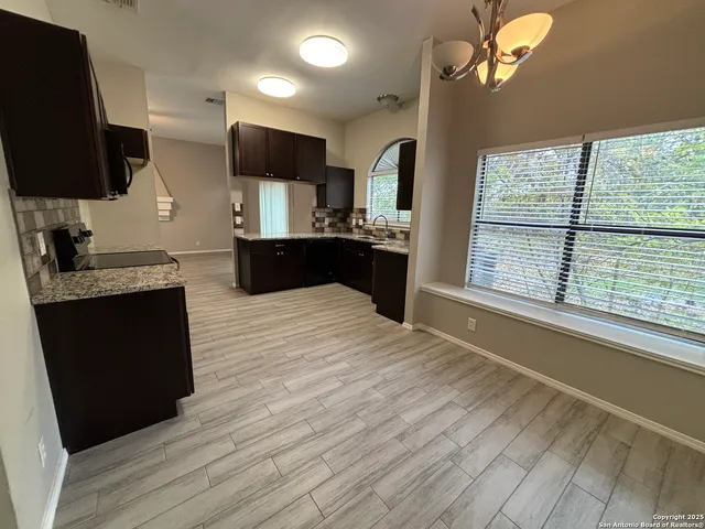 a large kitchen with stainless steel appliances a large counter top a stove and a refrigerator