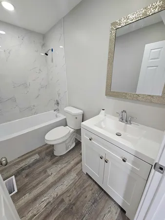 a bathroom with a double vanity sink toilet a mirror and shower